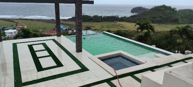 Clifftop infinity pool with green cloudy water before treatment